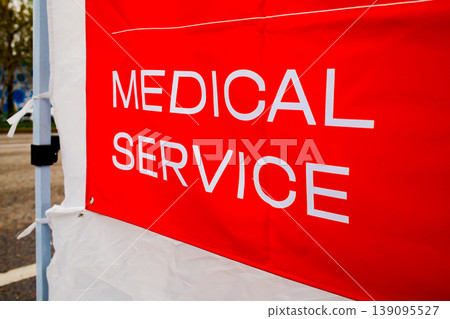 Red Medical Service banner sign at outdoor sport running marathon race event first aid station tent Red Medical Service banner sign at outdoor sport running marathon race event first aid station tent 139095527