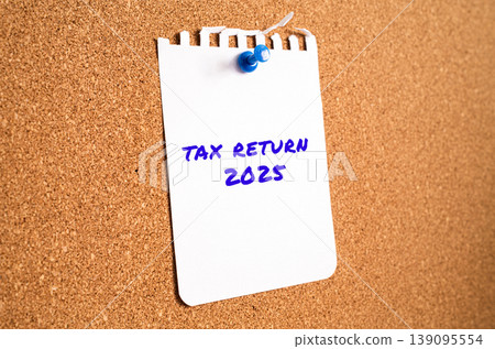 Tax Return 2025 handwritten note on notepad pinned on cork bulletin board. USA annual filing deadline concept 139095554