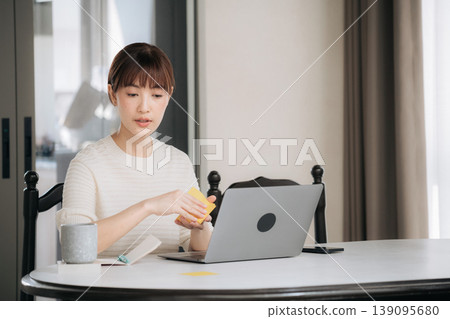 Focused asian woman at home working on business studying online via technology 139095680
