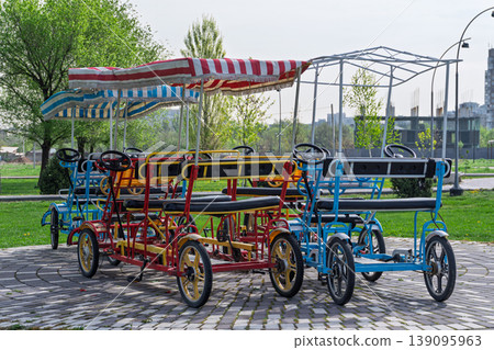 Colorful four wheel pedal cars parked in a green public park Colorful four wheel pedal cars parked in a green public park 139095963