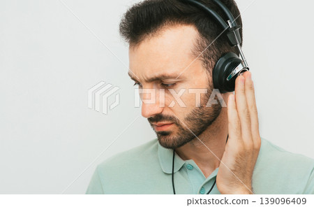 Audiometry. Mixed race man during the hearing test. Testing the patient hearing using special headphones in a hearing clinic Audiometry. Mixed race man during the hearing test. Testing the patient hearing using special headphones in a hearing clinic 139096409