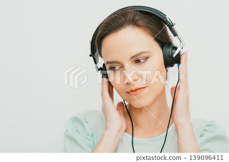 Hearing test, hearing diagnostic. A woman wearing headphones having an audiometry test isolated in white 139096411
