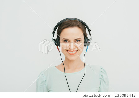 Audiometry. Beautiful adult woman during the hearing exam. Testing the patient hearing using special headphones in a hearing clinic 139096412