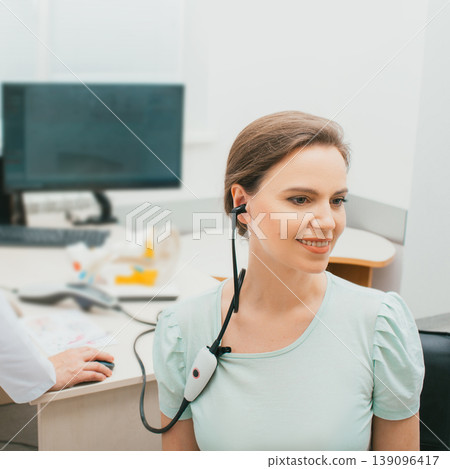 Impedance audiometry, tympanometry. Caucasian woman having a hearing test with special medical equipment in a hearing center Impedance audiometry, tympanometry. Caucasian woman having a hearing test with special medical equipment in a hearing center 139096417
