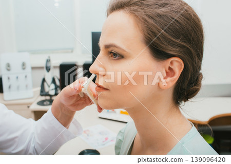 Female patient during nose check procedure, diagnosis and treatment of nasal disease. Sinusitis treatment 139096420