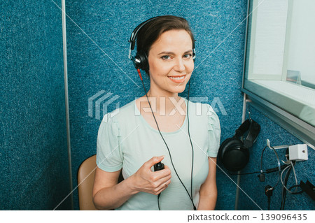 Audiometer hearing test. Adult beautiful woman getting a hearing test at the special audio room Audiometer hearing test. Adult beautiful woman getting a hearing test at the special audio room 139096435