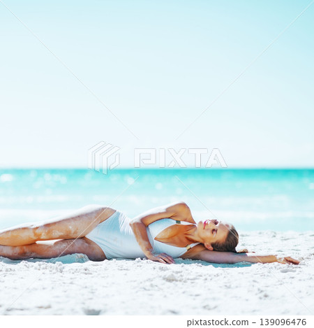 Young woman laying on beach 139096476