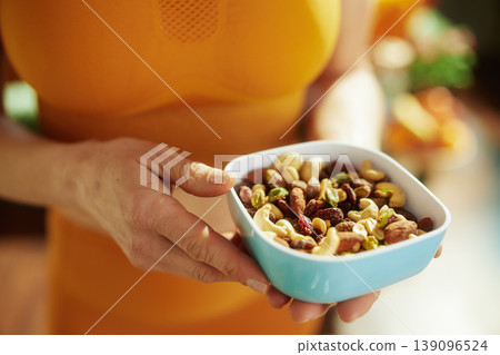 Woman Holding a Bowl of Mixed Nuts and Dried Fruit 139096524