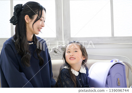 一位日本家長和孩子正在交談,旁邊放著書包。 一位日本家長和孩子正在交談,旁邊放著書包。 139096744