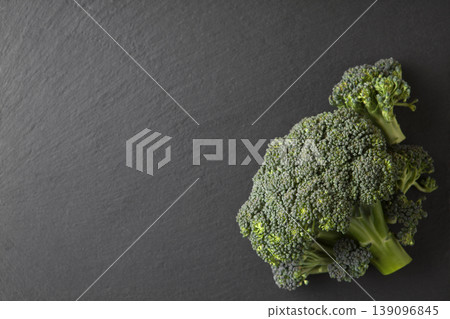 Organic Broccoli on Gray Granite Table. Green Broccoli on Dark Stone Surface Minimal Style. Organic Broccoli on Gray Granite Table. Green Broccoli on Dark Stone Surface Minimal Style. 139096845