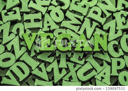 Inscription vegan on pile of old vintage wooden letters. Inscription vegan on pile of old vintage wooden letters. 139097531