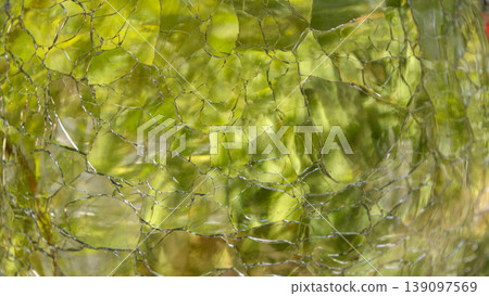 A shimmering green crushed glass texture that transmits light. 139097569