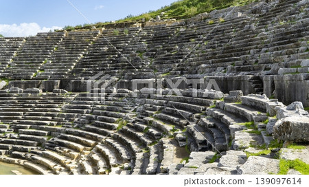 Ancient stone seating of the Hellenistic theater at Letoon ancient city, showing curved rows, weathered textures and terraced structure near city of Xanthos, Mugla, Turkey Ancient stone seating of the Hellenistic theater at Letoon ancient city, showing curved rows, weathered textures and terraced structure near city of Xanthos, Mugla, Turkey 139097614