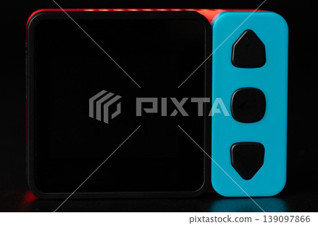 Red and blue device with side buttons on a dark background Red and blue device with side buttons on a dark background 139097866