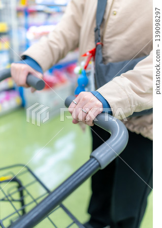 Shopping at the supermarket: Hands operating the shopping cart Shopping at the supermarket: Hands operating the shopping cart 139098297
