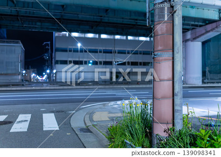 A quiet road scene stretching through a residential area late at night. 139098341