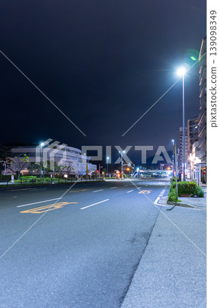 A quiet road scene stretching through a residential area late at night. A quiet road scene stretching through a residential area late at night. 139098349