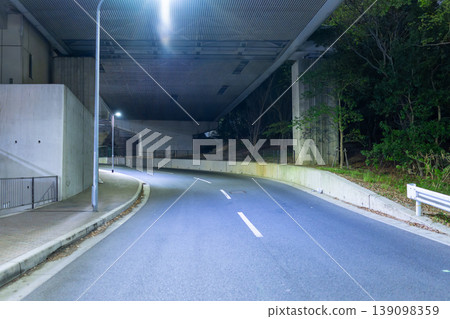 A deserted cityscape illuminated by streetlights in the dead of night 139098359