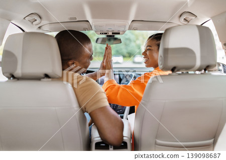 Black couple giving high five in car, smiling woman celebrating with man Black couple giving high five in car, smiling woman celebrating with man 139098687