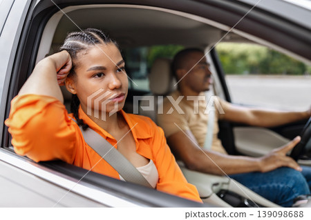 Thoughtful young black woman looking out of car window while traveling Thoughtful young black woman looking out of car window while traveling 139098688