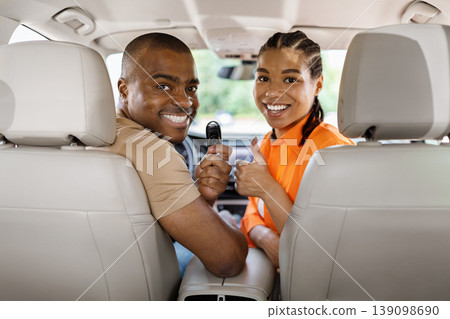 Happy young African American couple showing car key inside vehicle Happy young African American couple showing car key inside vehicle 139098690