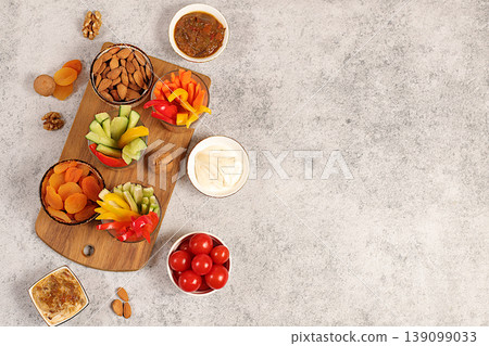 Middle East plate, Healthy food cuisine background with hummus bowl and raw vegetable sticks, nuts and dried apricots. Hummus platter with appetizers,traditional vegan snacks,oriental cuisine concept Middle East plate, Healthy food cuisine background with hummus bowl and raw vegetable sticks, nuts and dried apricots. Hummus platter with appetizers,traditional vegan snacks,oriental cuisine concept 139099033