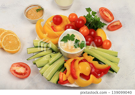 Healthy food kitchen background with hummus bowl and raw vegetable sticks, nuts and dried apricots. Hummus platter with appetizers, Middle Eastern plate, traditional vegan snacks, Healthy food kitchen background with hummus bowl and raw vegetable sticks, nuts and dried apricots. Hummus platter with appetizers, Middle Eastern plate, traditional vegan snacks, 139099040