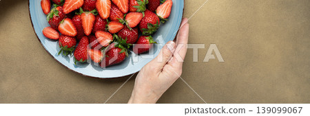 Fresh strawberries on plate hand holding Fresh strawberries on plate hand holding 139099067