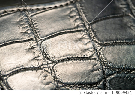 A luxurious black crocodile leather texture background. A luxurious black crocodile leather texture background. 139099434