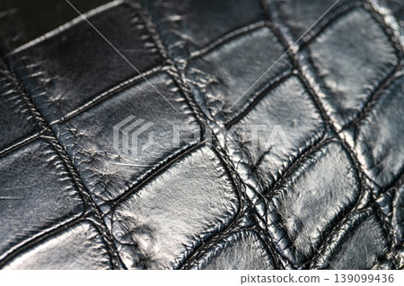 A luxurious black crocodile leather texture background. A luxurious black crocodile leather texture background. 139099436