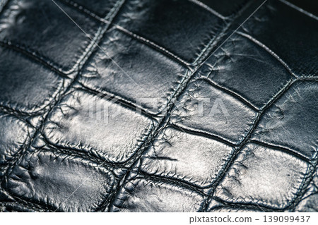 A luxurious black crocodile leather texture background. A luxurious black crocodile leather texture background. 139099437
