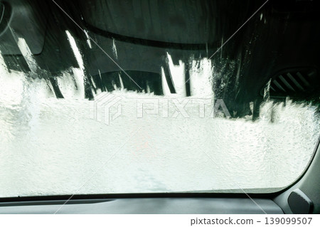 An abstract background of foam and a windshield as seen from inside a car wash. 139099507