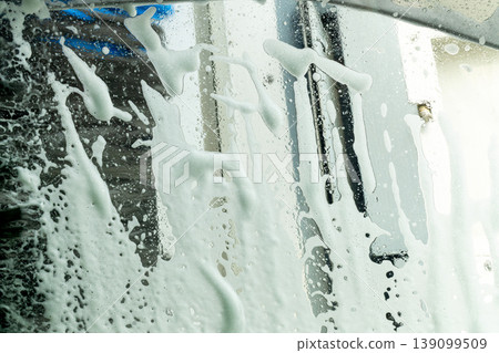 An abstract background of foam and a windshield as seen from inside a car wash. 139099509
