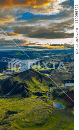 Aerial View of Iceland's Moss Covered Hills, Rivers, and Snowy Peaks 139099791