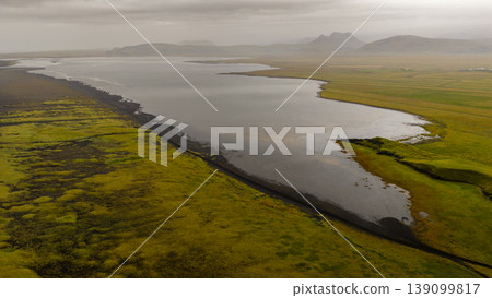 Aerial View of Icelandic River with Green Fields and Volcanic Soil Aerial View of Icelandic River with Green Fields and Volcanic Soil 139099817