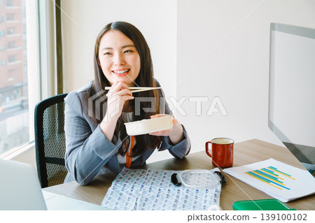 Businesswomen eating their lunch in the office 139100102
