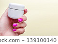 Manicure cosmetics cream skincare hand with pink nails holding white jar for beauty care. Spa moisturizing product scene for skin, cuticle, body care, salon procedure and cosmetic treatment. 139100140