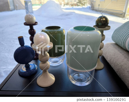 Modern designer candlesticks and vases by the window Modern designer candlesticks and vases by the window 139100291