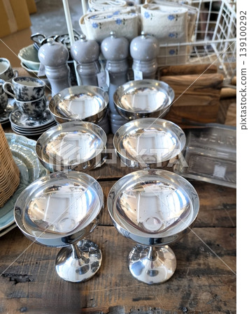 Silver metal dessert bowls on a wooden table Silver metal dessert bowls on a wooden table 139100292