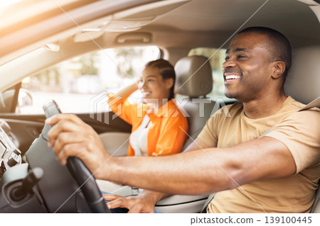 Happy young African American couple enjoying drive in modern car Happy young African American couple enjoying drive in modern car 139100445