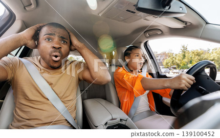 Young African American couple reacting with fear inside car during driving situation Young African American couple reacting with fear inside car during driving situation 139100452