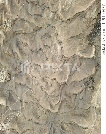 The details of sandy soil patterns illuminated by sunlight. The earthy textures create interesting shapes in a natural outdoor setting during the day. The details of sandy soil patterns illuminated by sunlight. The earthy textures create interesting shapes in a natural outdoor setting during the day. 139100477