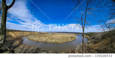 The Don River bending gently at the Krivoborye natural landmark in the Voronezh region. Bright blue sky stretches above the landscape and hills form the background. 139100553