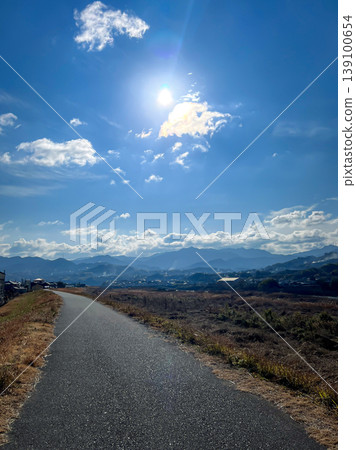 日本鄉村景觀:一條河岸公路和起伏的山脈在晴朗的冬日夜空中閃閃發光。 日本鄉村景觀:一條河岸公路和起伏的山脈在晴朗的冬日夜空中閃閃發光。 139100654