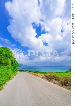 A refreshing road on Ishigaki Island stretches towards the white clouds and the blue sea. A refreshing road on Ishigaki Island stretches towards the white clouds and the blue sea. 139100744