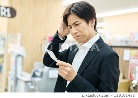 一名男子看到收據上的價格後很不滿意。 一名男子看到收據上的價格後很不滿意。 139101458