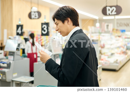 A man is dissatisfied after seeing the price on the receipt. A man is dissatisfied after seeing the price on the receipt. 139101460