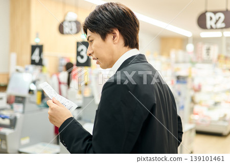 A man is dissatisfied after seeing the price on the receipt. A man is dissatisfied after seeing the price on the receipt. 139101461