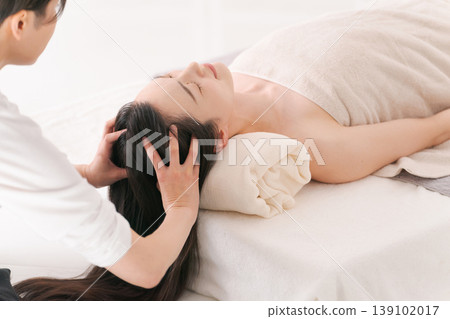 A woman receiving a head spa treatment. 139102017