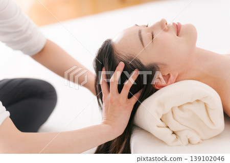 A woman receiving a head spa treatment. A woman receiving a head spa treatment. 139102046